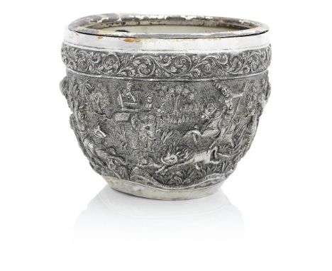 AN INDIAN OR BURMESE WHITE METAL JARDINIERELate 19th Century Embossed in high relief with a continuous hunting scene featurin