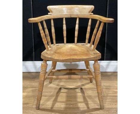 An early 20th century beech and elm smoker’s bow or desk elbow chair, by W H Glenister, High Wycombe, the underside branded G