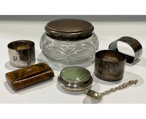 A George V silver mounted dressing table jar, Birmingham 1921; three silver napkin rings, 84g; a continental silver spoon mar