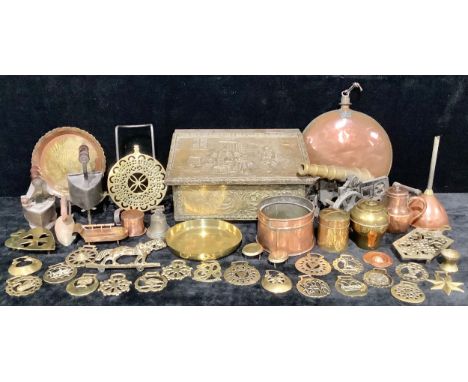 A brass and cast metal desk cannon, 44cm long; a large circular copper hot water bottle, 30cm diameter; brass trivets; Victor