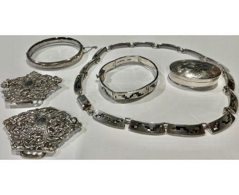 A Victorian silver nurse's buckle, London 1892, 43g; a silver bangle, 11g; a silver pill box, marked 925, 21g; a base metal n