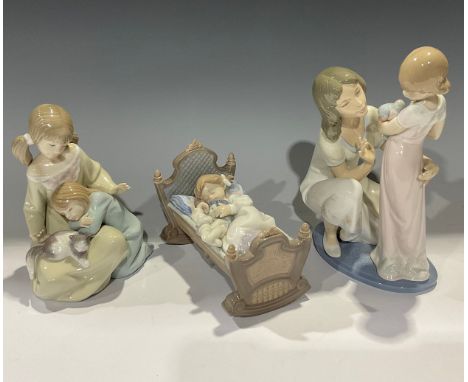 A Lladro figure group, A Mother's Touch, 5989, 24cm; two others, Rock A Bye Baby, 5717; Little Sister, 1534 (3) 