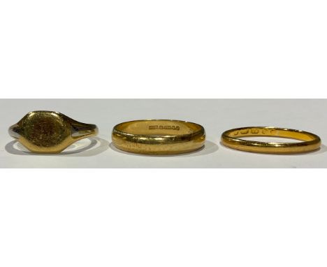 A 22ct gold wedding band, ring size J, 1.9g; an 18ct gold wedding band, size O, 3g; an 18ct gold signet ring, size K, 3.6g (3