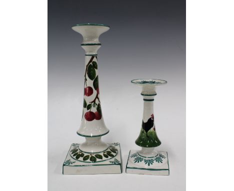 Wemyss Ware candlesticks, patterns to include plums and cockerel, impressed marks,  (2) 12 x 30cm. 