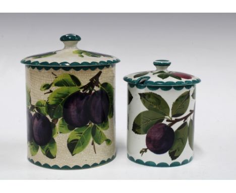 Two Wemyss Ware preserve jars with covers, handpainted plums pattern, with painted marks, the larger jar retailed by Thos Goo