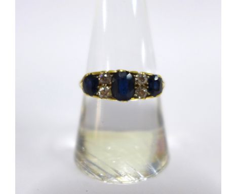 Sapphire and diamond ring claw set with three cushion cut sapphires and four small old round-cut diamonds, worn marks to the 