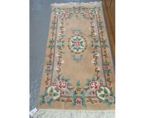 Two similar Chinese cream ground floral and foliate wash ground carpets, together with a larger pink ground floral and foliat