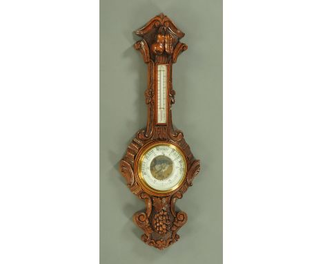 A large Edwardian carved oak banjo barometer, aneroid, with fruit and foliate carved case, height 108 cm (see illustration). 