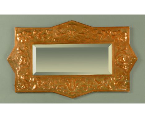 Attributed to The Keswick School of Industrial Arts, a copper framed mirror embossed with mythical birds, scrolls and foliage