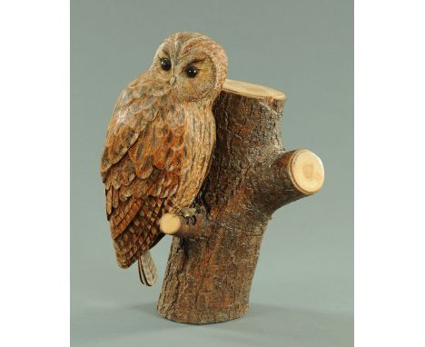 A carved and painted wood model of an owl, by Stewart Males, naturalistically modelled seated upon a branch of a tree stump, 