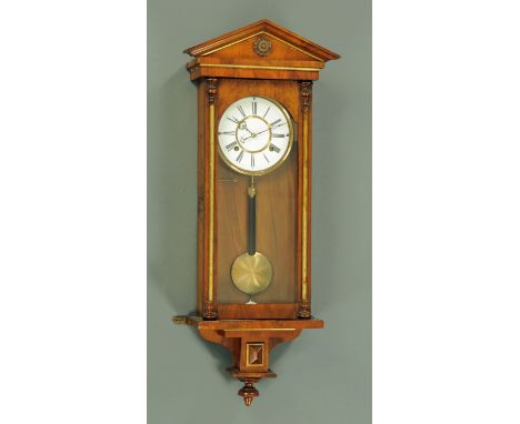 A 19th century walnut veneered Vienna style regulator wall clock, having an enamel dial with 8 day movement, the columns and 