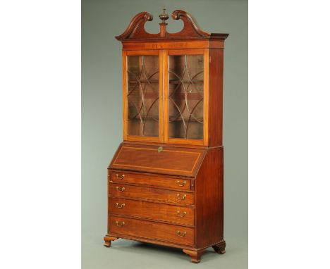 A George III mahogany bureau bookcase, with swans neck pediment above a pair of glazed doors with wooden astragals, with slop