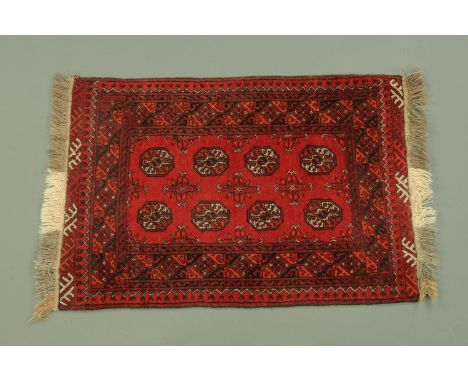 An Indian fringed rug, with centre rectangular panel with eight repeating motifs with multiple line border, 132 cm x 84 cm.