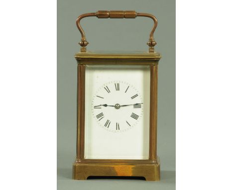 An Edwardian brass cased carriage clock, the enamel dial with Roman numerals, striking on a gong.  Height 18 cm. 