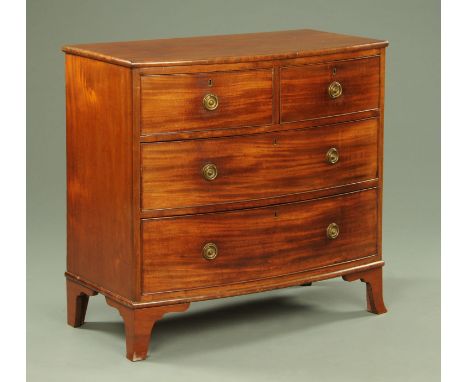 A George III mahogany bowfronted chest of drawers, with two short and two long drawers with brass drop handles with circular 