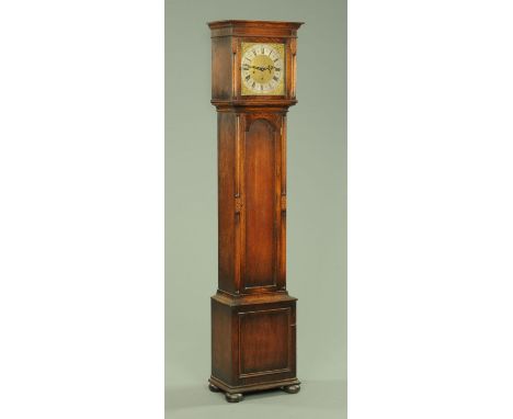 An oak longcase clock, circa 1930, with three-train spring driven movement, long trunk door and raised on bun feet.  Height 1