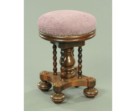 A Victorian piano stool, having an upholstered revolving adjustable top supported upon a bulbous column, flanked by bobbin tu