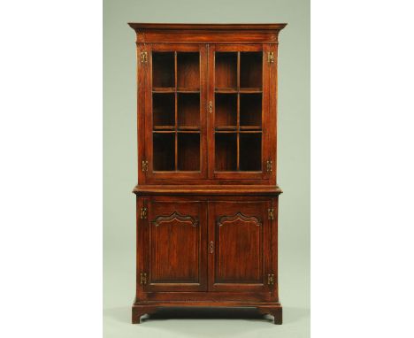 An oak bookcase, with moulded cornice above a pair of glazed doors with wooden astragals and with pair of panelled doors bene