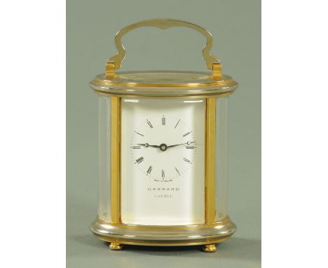 An oval brass cased carriage clock timepiece, retailed by Garrards of London, height excluding handle 11.5 cm (see illustrati