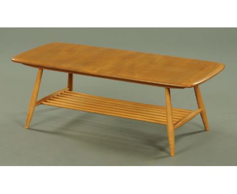 An Ercol light elm coffee table, with rectangular top with a spindle under tier all upon turned legs. 105 cm wide, 46 cm deep