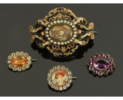A 19th century in memoriam brooch, the central roundel with a lock of hair framed by seed pearls in a gold metal and black en