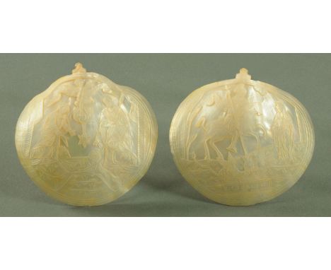 A pair of Italian carved mother of pearl shells, 19th century, each carved with a scene to include Christ in the manger and S