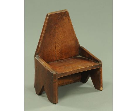 A 19th century small oak stool, of angled form and silhouette sides, width 34.5 cm.