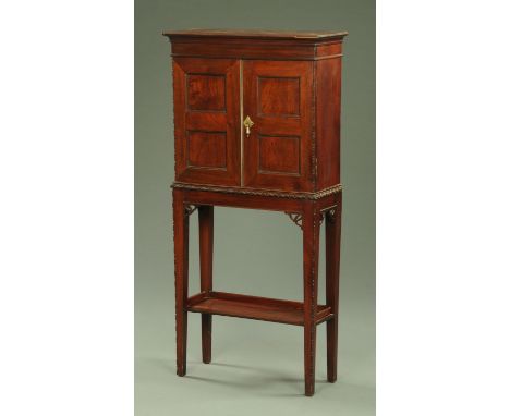 A late 19th century mahogany shallow cabinet on stand, having a cavetto moulded pediment above two square panelled doors one 