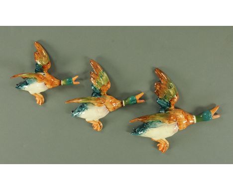 A graduated set of three Beswick flying mallard wall plaques, shape number 596-1 to 596-3, moulded and printed marks. CONDITI