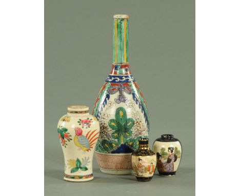 A Japanese polychrome enamel sake bottle, circa 1700, decorated with plants and flowers, waves and ribbons, all beneath a gre