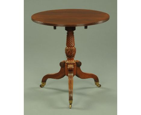 A Regency mahogany tripod table, with moulded edge and snap action to the circular top supported by a turned and carved colum