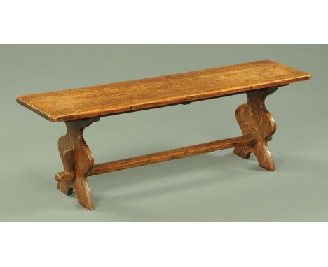 An early 20th century oak stool, the rectangular top with silhouette end supports united by a centre stretcher.  Length 104 c