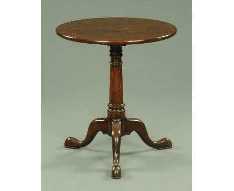 A George III oak tripod table, with fixed top, turned column and three downswept legs terminating in pad feet, diameter 60 cm