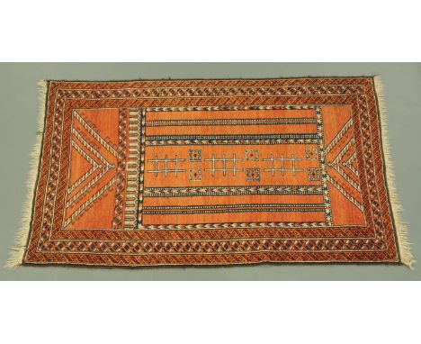 An Eastern fringed rug, principle colours red, blue and beige, with centre rectangular panel and multiple line border.  197 c