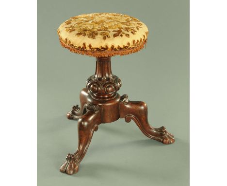 A Victorian mahogany piano stool, mid 19th century, having an upholstered revolving top upon a fluted stem in turn upon three