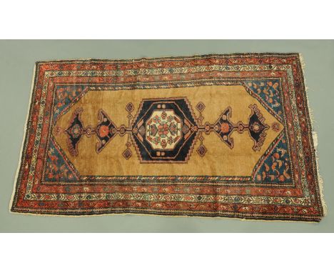 A North West Persia Kurdish rug, with centre rectangular panel, corner spandrels and multiple line border, principal colours 