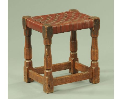 A Robert Mouseman Thompson of Kilburn stool, dark oak, with latticework leather top and bearing the typical mouse trademark. 
