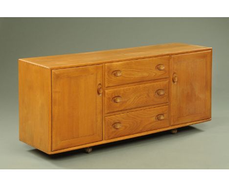 An Ercol light elm sideboard, having three central drawers flanked by cupboard doors with interior shelves. Width 155 cm, hei
