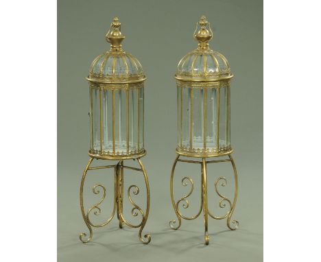 A pair of metal and glass lanterns, each with carrying handle and raised on a tripod stand, height excluding carrying handle 