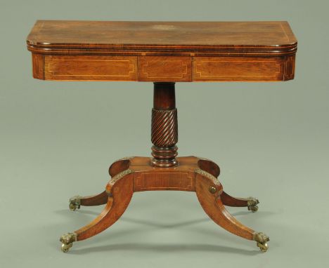 A Regency rosewood turnover top games table, with tooled leather playing surface, raised on a turned column and four downswep