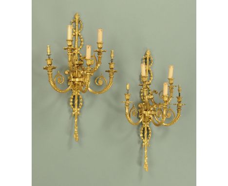 A pair of gilt metal five branch wall light sconces.  Height 80 cm, width 49 cm (see illustration). 