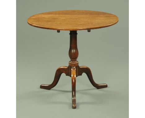 A George III mahogany tripod table, circular, with snap action, turned column and downswept legs terminating in pad feet.  Di