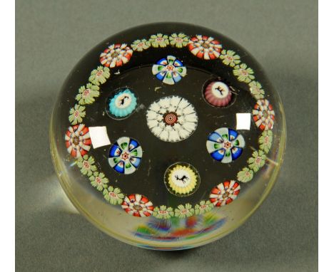 A Baccarat style paperweight, with three canes, with goat, stag and dog, framed by floral canes.  Diameter 7.9 cm, height 5.1