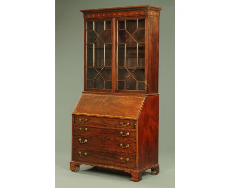A George III mahogany bureau bookcase, the top half with moulded dentil cornice above a pair of glazed doors, the base with s