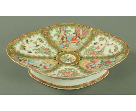 A large Canton enamel oval shaped dish, mid 19th century, the body slightly scalloped with panels of figures, birds and butte