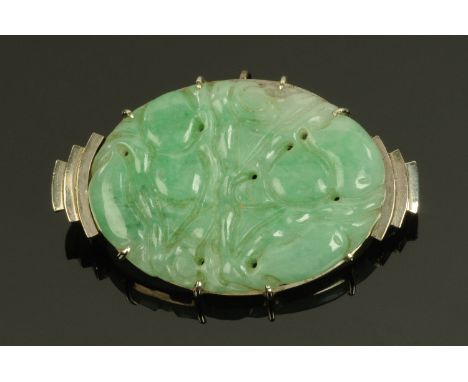 A 9 ct white gold jade set brooch, with safety chain.  48 mm x 30 mm.