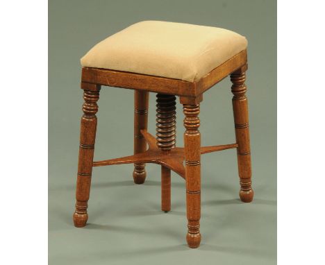 A Regency mahogany square topped stool, stuffover, raised on turned legs with centre height adjustment.  Width 33 cm. 