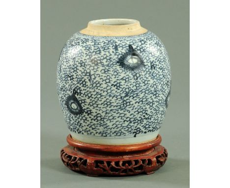 A Chinese blue and white ginger jar, 19th century, decorated with stylised lotus scroll decoration, upon a stained wood stand