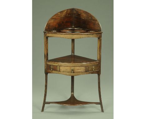 A late Georgian mahogany corner washstand, fitted for a basin, with single drawer and raised on splayed legs with low shelf. 