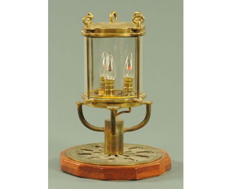 A table light, manufactured from a ships sealed component, on a wood base.  Height 41 cm.